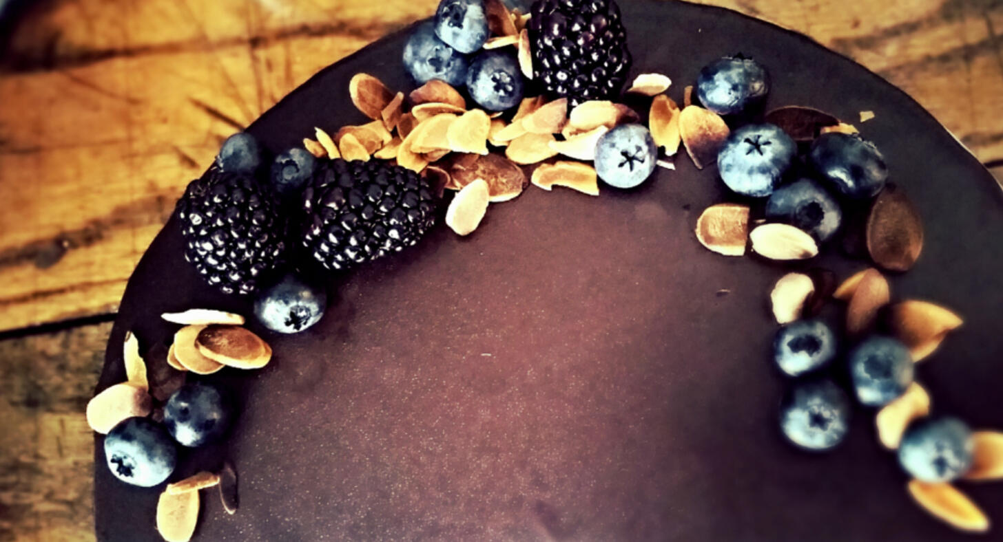wreath of nuts and berries on top of chocolate cake