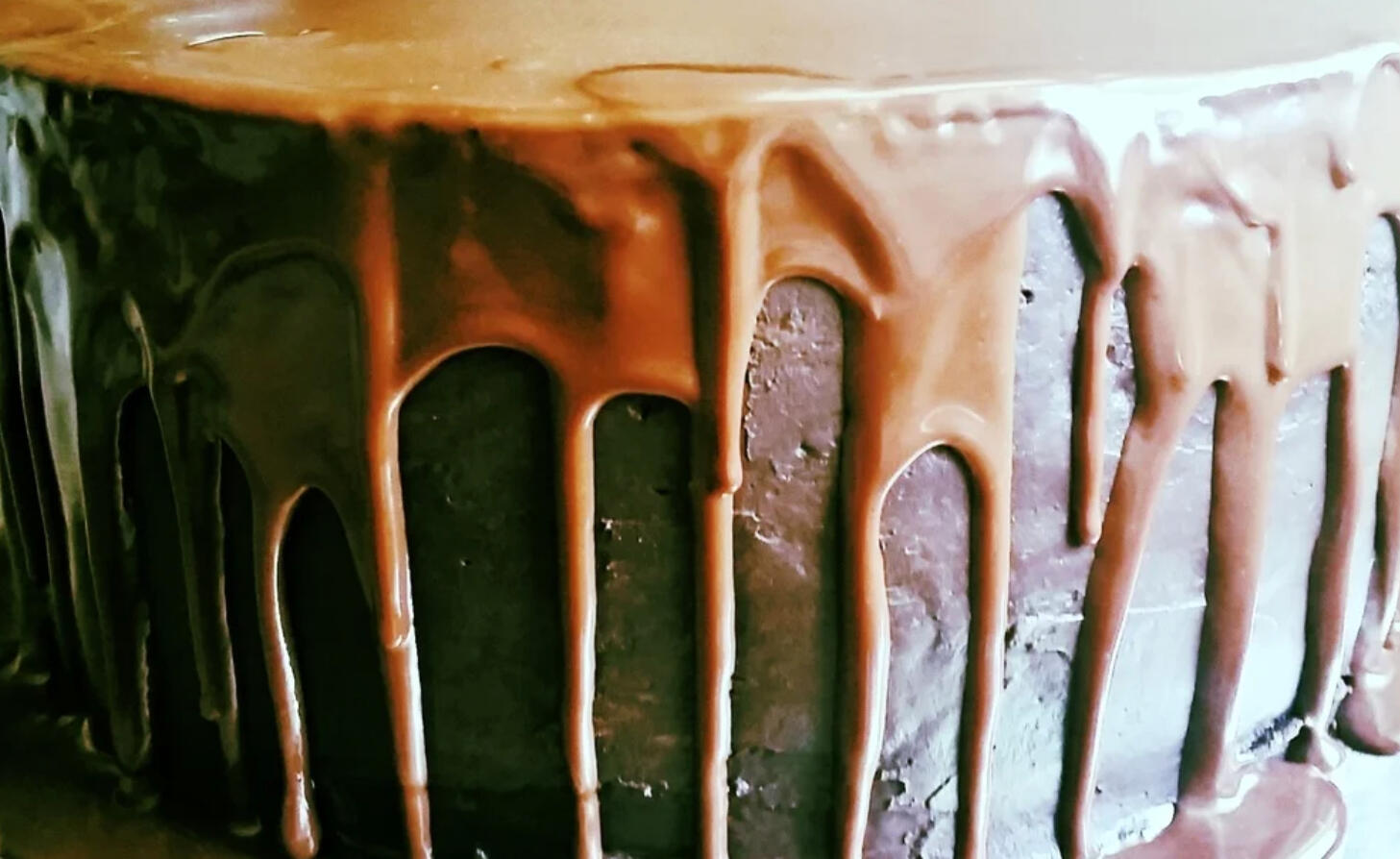 chocolate cake with milk chocolate rum ganache pouring over the sides